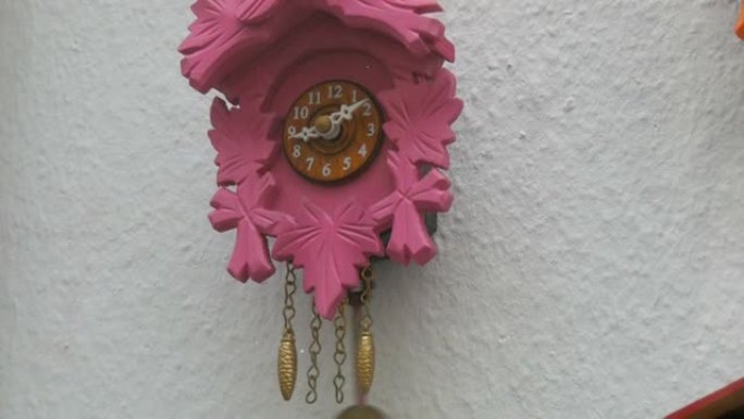 一家钟表店橱窗里有摆锤的粉色钟挂钟