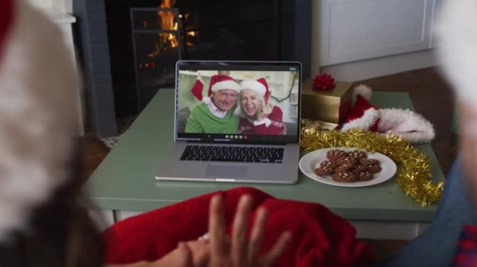 圣诞节时，白人夫妇在笔记本电脑上与高级夫妇进行视频通话