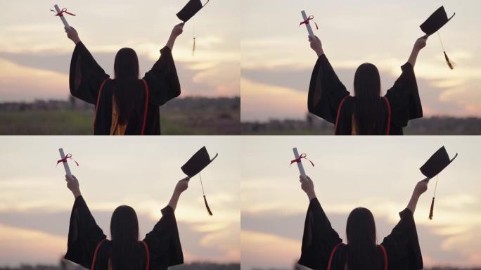 毕业于大学的女学生站在日落的户外时间，毕业于剪影日落概念。