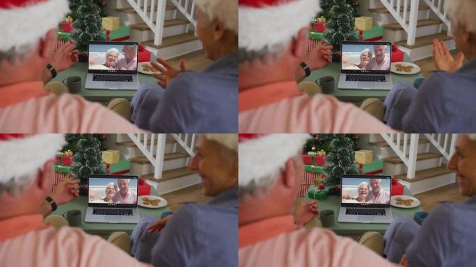 圣诞节时，快乐的高加索高级夫妇在笔记本电脑上与高级朋友进行视频通话