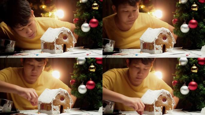 亚洲男孩看完DIY姜饼屋后，圣诞节庆祝生活方式的概念。