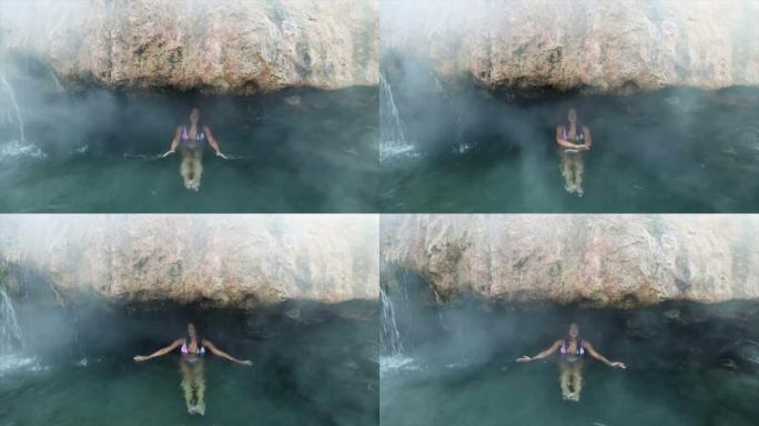 年轻女子在山洞的地下河中游泳，悬崖之间有淡水。