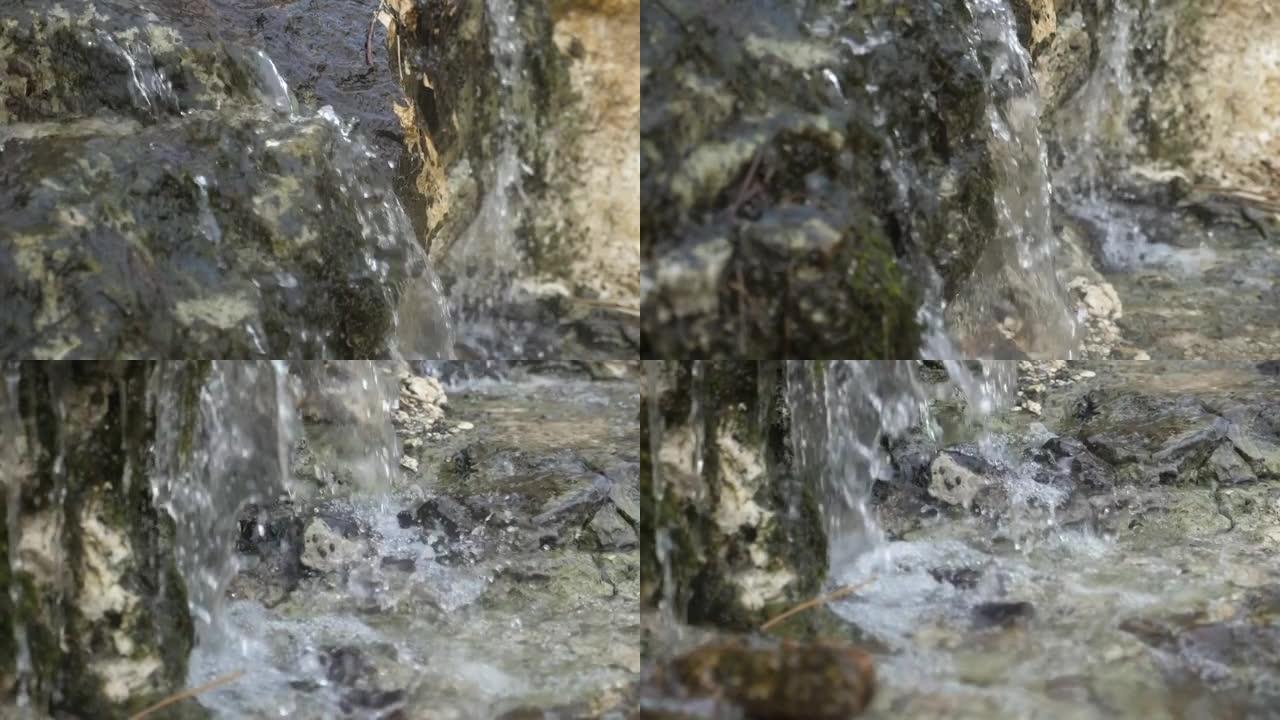 山区的水晶瀑布，光滑的水滴落在slo-mo的苔藓石头上