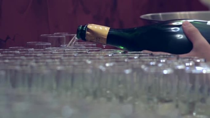 酒保把香槟倒在放在靠近门66的桌子上的玻璃杯中