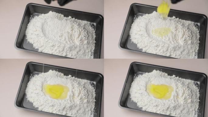 鸡蛋落入面粉中。通过慢动作，鸡蛋落入面粉烤盘中。顶视图