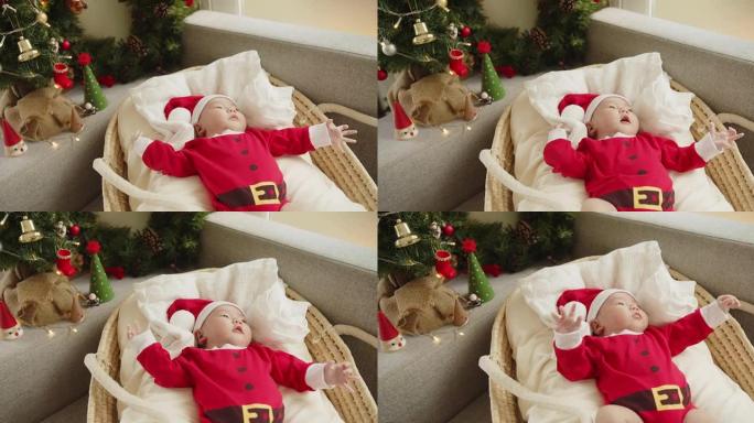 肖像可爱的亚洲新生婴儿圣诞老人帽子和红色紧身衣躺在床上，圣诞快乐，新年快乐，童年，假期概念