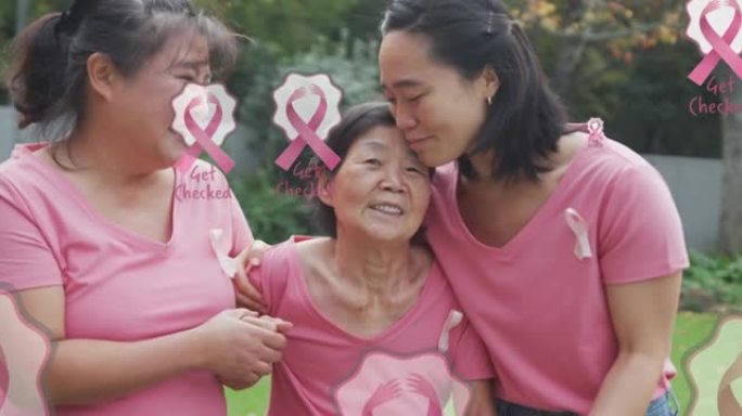 粉红色乳腺癌丝带的动画在快乐的多代亚洲妇女拥抱在花园