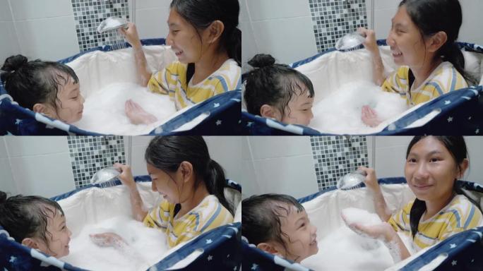 快乐的亚洲孩子们一起在家里的塑料浴缸里嬉笑，生活理念。