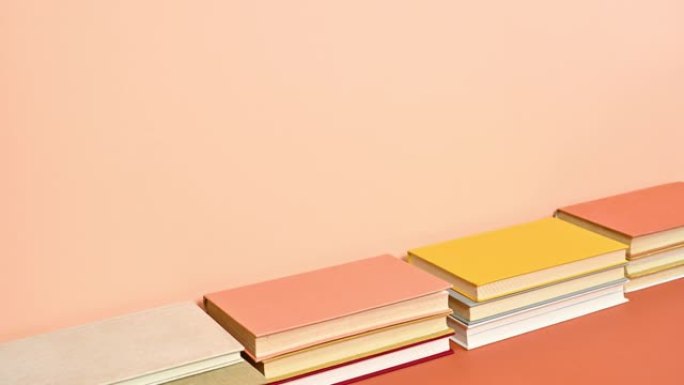 一堆暖色的精装书籍出现在深而明亮的橙色主题上。停止运动