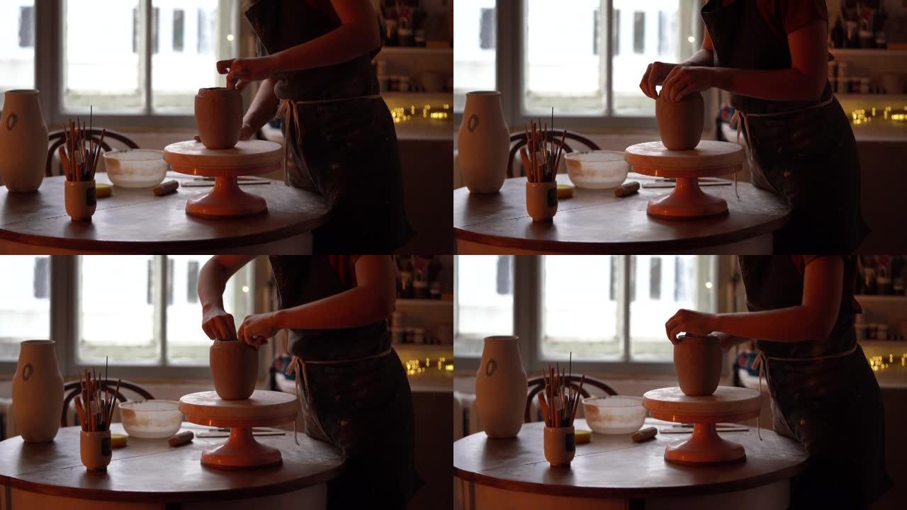 女陶艺师在陶艺工作室制作陶罐。年轻的女陶艺家制作厨房用具