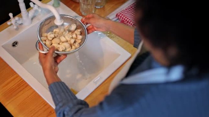 女人在家里厨房做午餐前洗白蘑菇