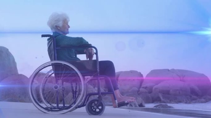 灯光在海滩上坐在轮椅上向海望去的白人妇女上移动的动画