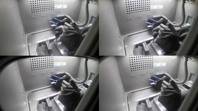 穿着孤立的黑色橡胶手套的工人清洁3d金属打印机内部的打印平台。戴手套的人清洁工业机器内的金属粉末。金