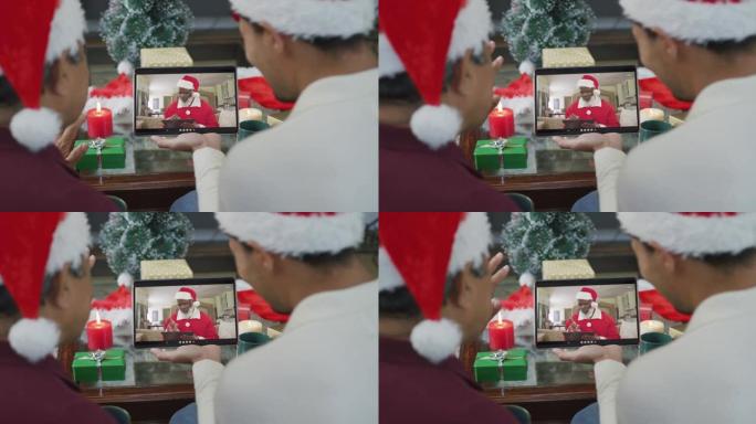 带有圣诞老人帽子的混血儿父子使用平板电脑进行圣诞视频通话屏幕上的圣诞老人