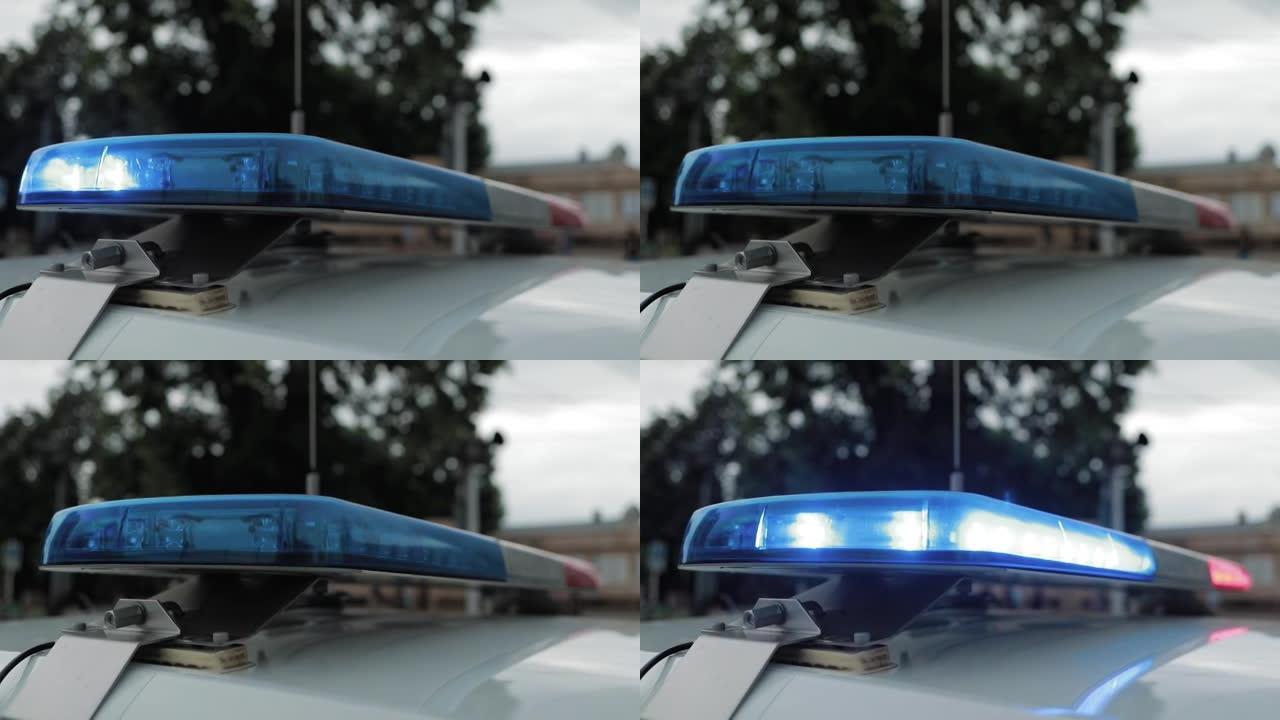 一名警官在巡逻车顶上闪灯。警车闪烁红色和蓝色。