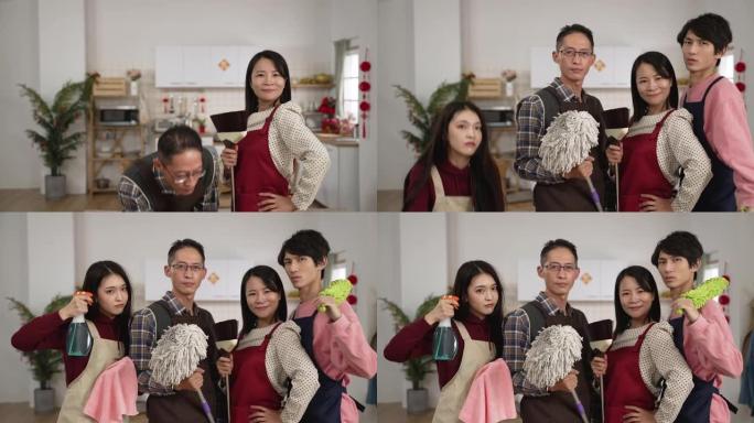 亚洲家庭成员手持拖把，喷雾和扫帚出现并在装饰好的家庭室内看着相机，准备在春节前进行春季大扫除