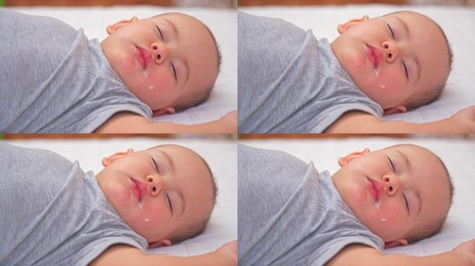 睡在床上的新生婴儿12-17个月大，唾液从婴儿的嘴角流出