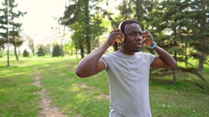 运动员在慢跑前通过智能手表在耳机上播放音乐