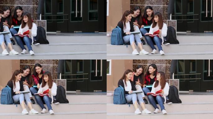 一组4个大学密友一起坐在楼下的教学楼上，以亲密的方式讨论教育和学习。青少年学生生活方式的概念。