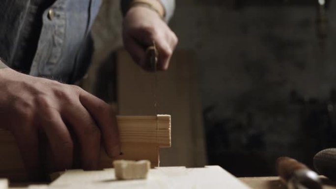 工匠用手锯在木板上切出燕尾榫。木工做燕尾榫