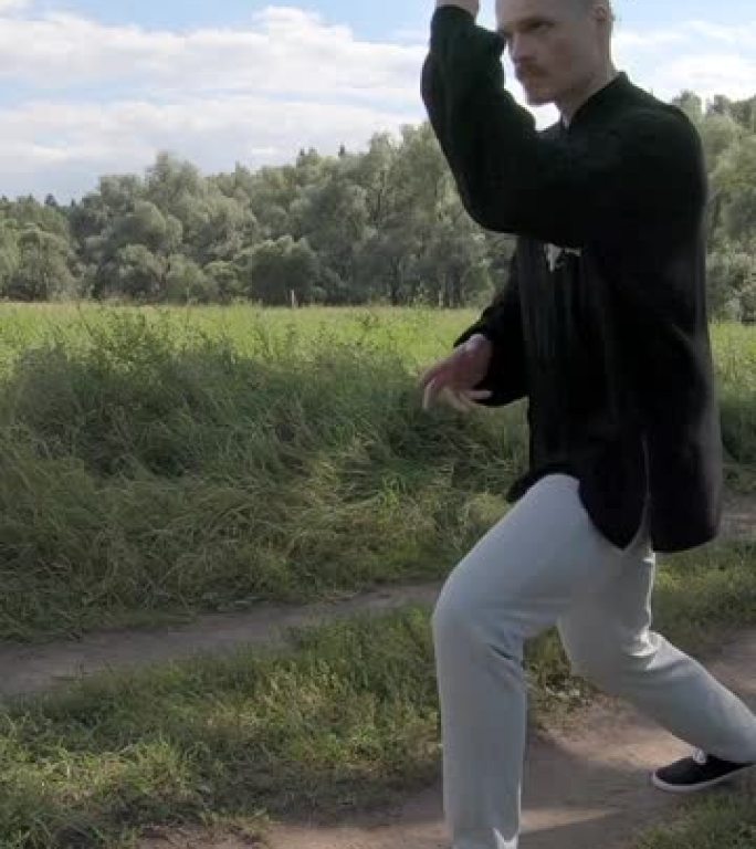 穿着中国服装的男人表演拳打脚踢-垂直视频