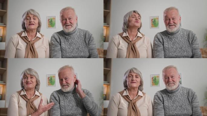 快乐的退休人员向网络摄像头挥手，白发祖父母的肖像在家中通过互联网交流