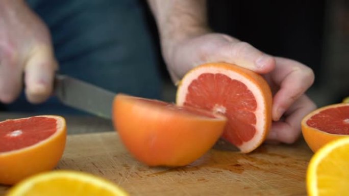 男性手正在切割成熟的葡萄柚，以制作柑橘汁，健康的生活方式，果汁