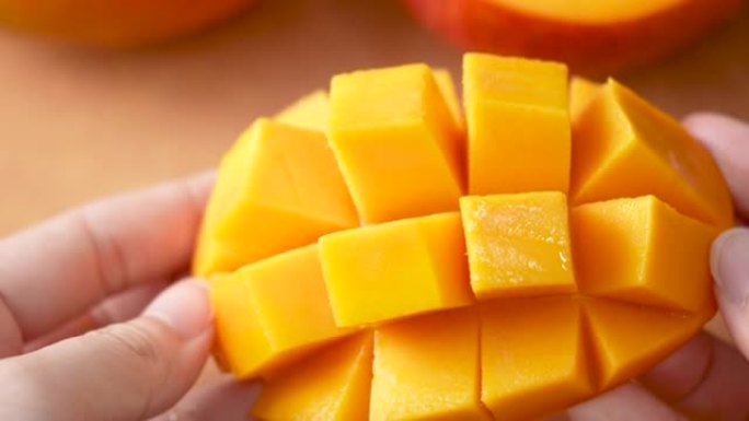切新鲜芒果水果，露出多汁的果肉丁。
