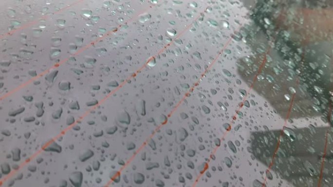 雨夹雪时汽车后窗覆盖着大滴水