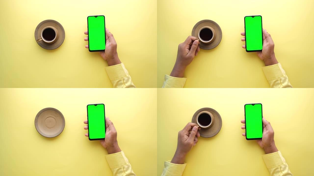 使用智能手机和喝茶的男士手的高角度视图