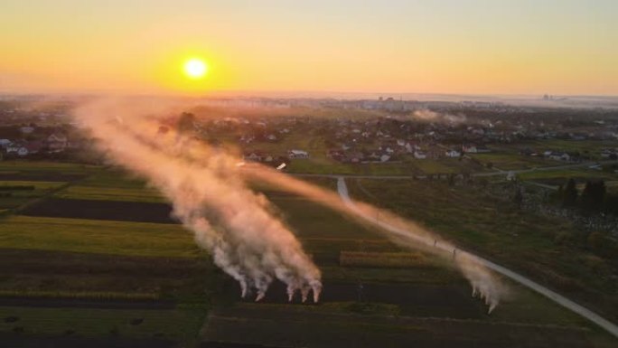 旱季农田干草和稻草茬燃烧的农业废物篝火的鸟瞰图，浓烟污染空气，导致全球变暖和致癌性烟雾。