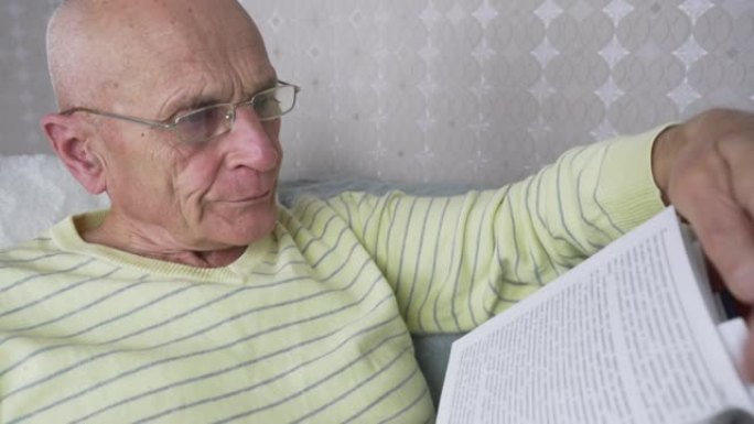 戴眼镜的成熟男性躺在沙发上看书