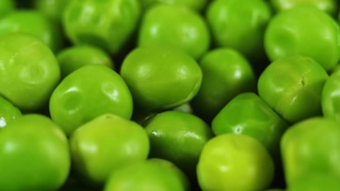 宏观拍摄新鲜有机豌豆。健康素食。关闭绿色豌豆背景旋转。蔬菜收获健康饮食。新鲜绿豌豆的美丽纹理特写。