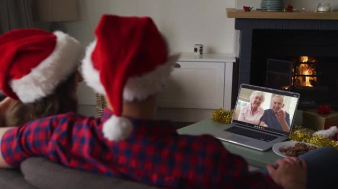 圣诞节时与祖父母进行视频通话的高加索夫妇