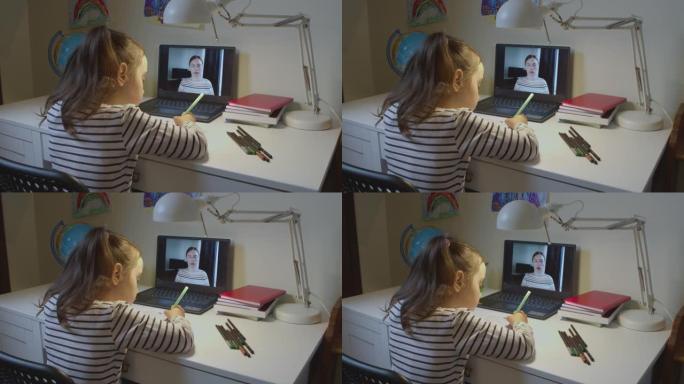可爱的高加索学龄前女孩，一个学生孩子，老师用笔记本电脑在线学习，在线远程学习，在家虚拟视频会议上与相