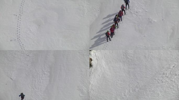 在印度26号线行走的一群游客的山坡陡峭上升上的雪地上的脚印