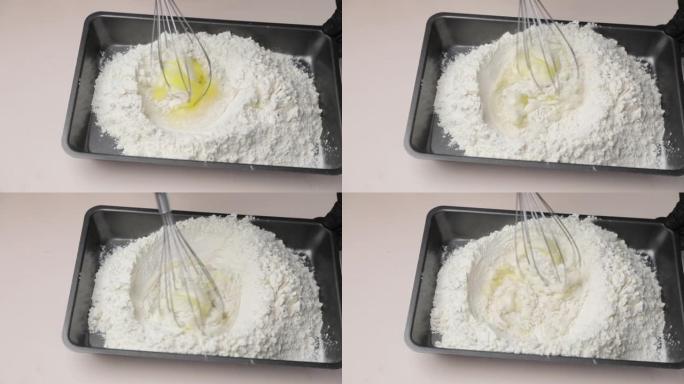 鸡蛋和面粉在白色桌子上的烤盘上混合。顶视图