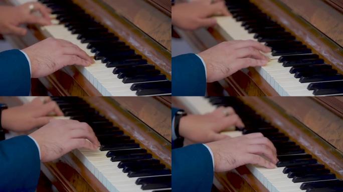 一个穿着蓝色衬衫的男人的手按一架旧钢琴唱歌。