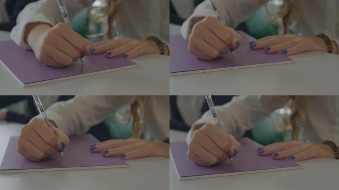 十几岁的女孩在紫色作文书上写名字