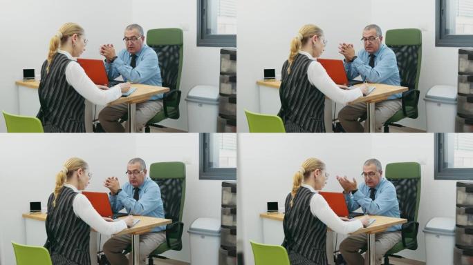 女人在办公室的办公桌旁填写合同文件，商人坐在笔记本电脑的前面，在咨询室与客户交谈