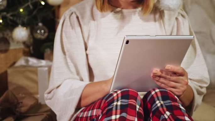 在庆祝圣诞节期间使用平板电脑的女人