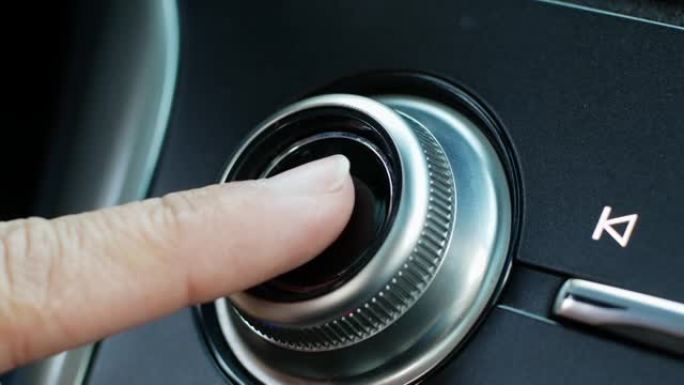 一名妇女通过按下现代汽车中的电源按钮来打开音频系统