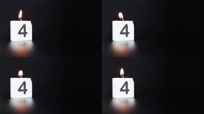 一根方形蜡烛，上面写着数字4被点燃并吹出，庆祝生日或周年纪念日。