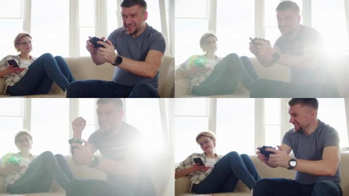 慢动作。幸福的夫妻坐在沙发上玩电子游戏，在恋爱中使用控制器一起玩在线电子游戏。