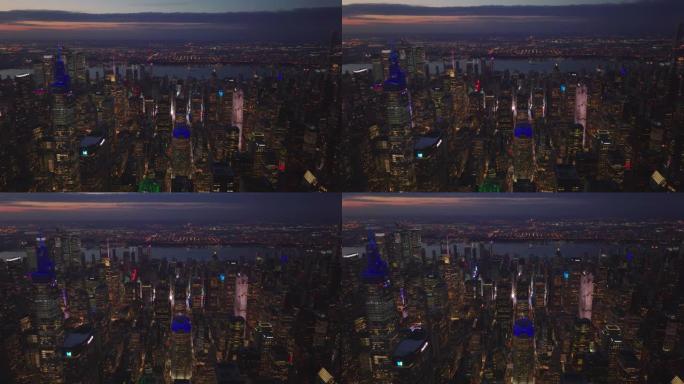 市中心摩天大楼上的各种颜色灯。夜景的空中全景镜头。美国纽约市曼哈顿