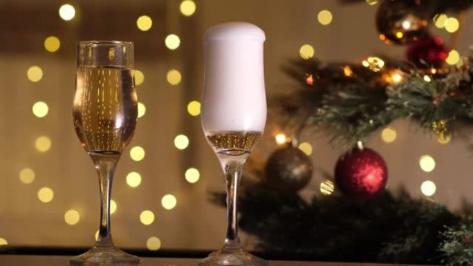 在圣诞树和闪烁的灯泡花环的背景下，香槟倒入眼镜中。新年晚会，冬天，节日心情。节日快乐，敬酒