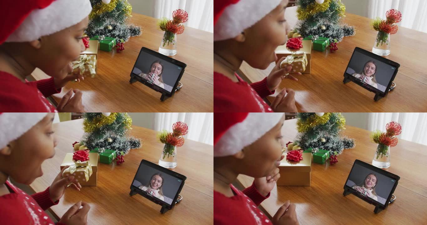 戴着圣诞老人帽子的非洲裔美国妇女使用平板电脑进行圣诞视频通话屏幕上的妇女