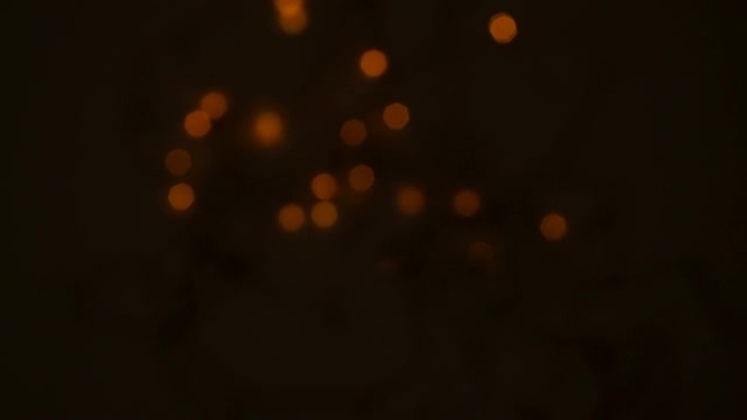 节日的五彩花环的灯光在夜晚在黑色背景上有节奏地闪烁。模糊的波克。节日的概念象征。4K。