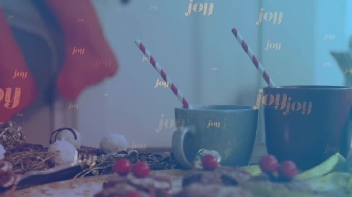 欢乐的动画文字落在圣诞节装饰品和热巧克力杯子上