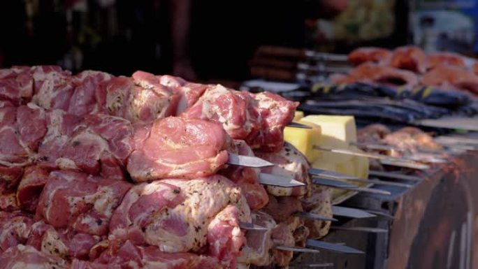 串上的许多生猪肉串躺在市场的露天柜台上。特写